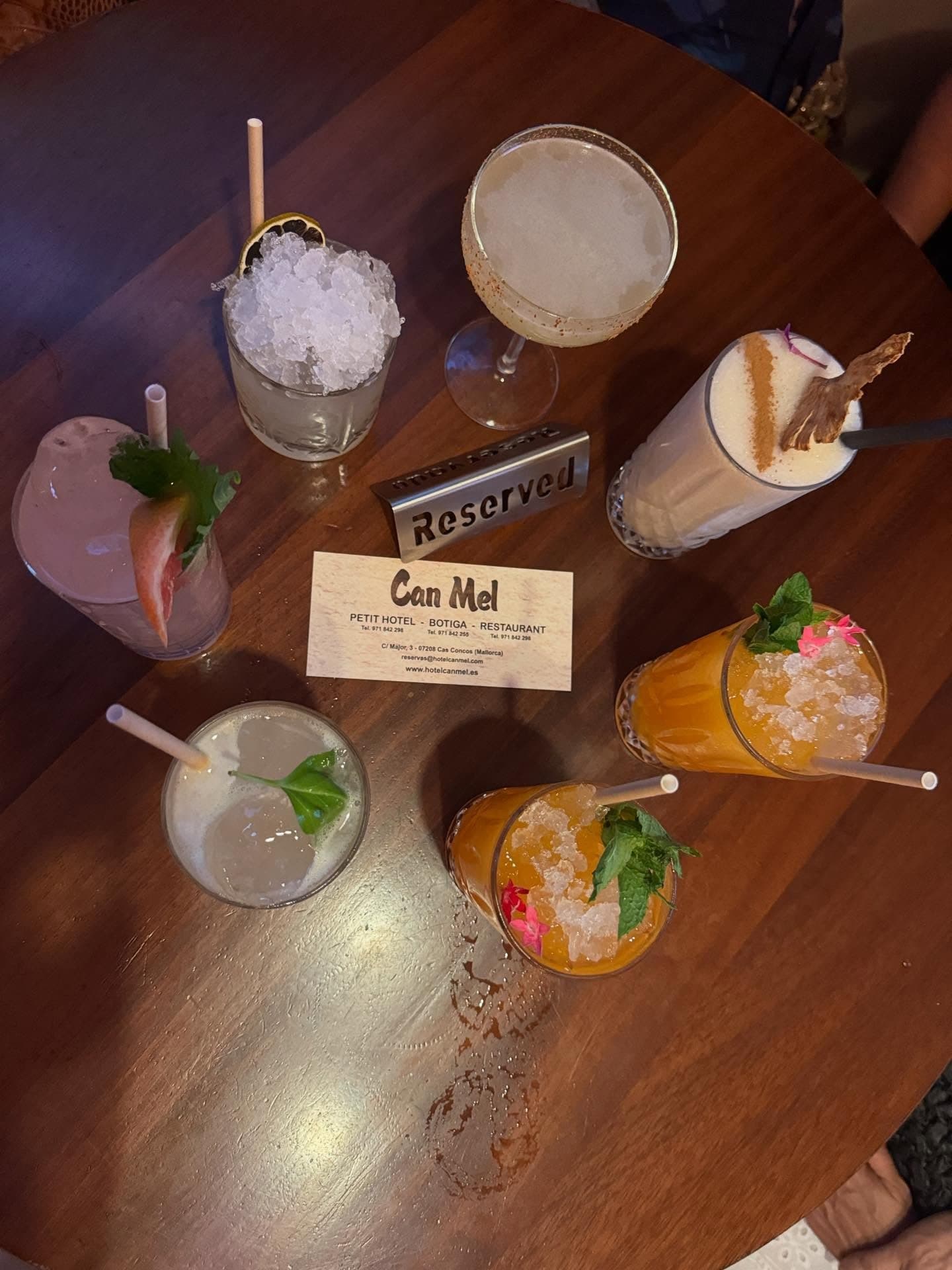 Mesa reservada con cócteles y la tarjeta de Can Mel