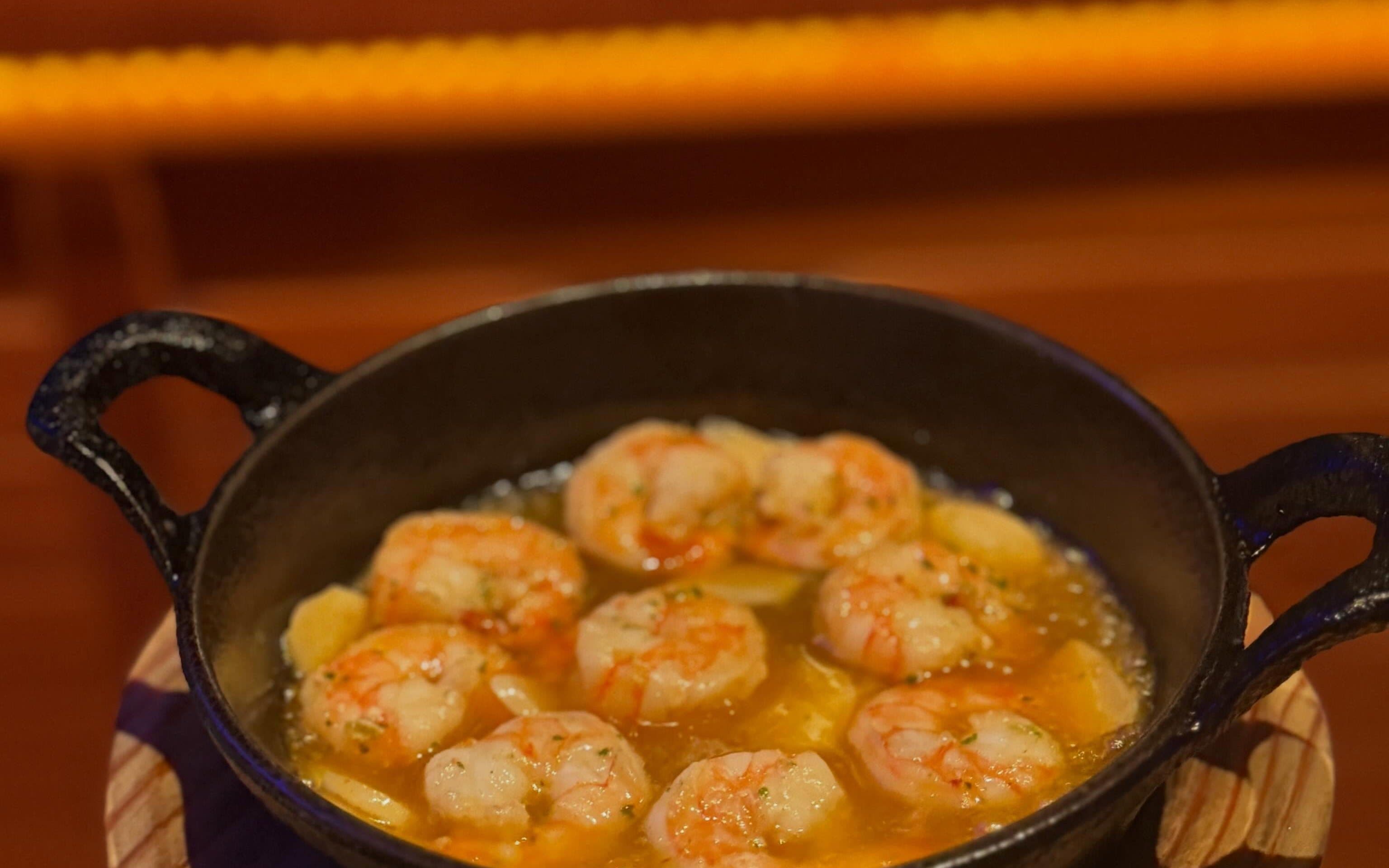 Una cazuela de gambas al ajillo servida en mesa