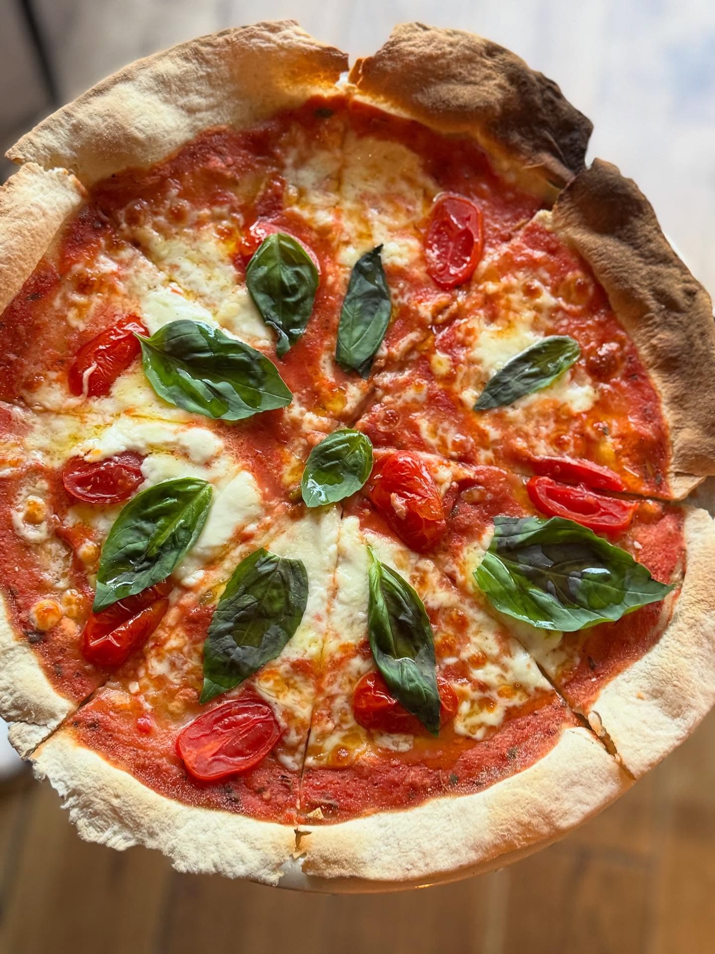Pizza margarita con tomate cherry y albahaca
